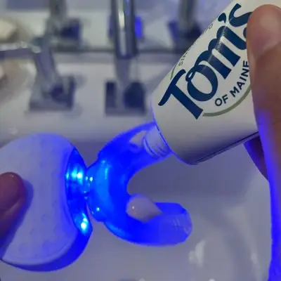 person uses SoniClean with toothpaste